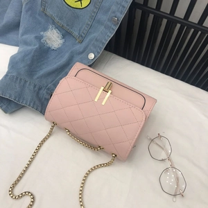 Close-up of pink quilted crossbody bag with gold chain strap and turn-lock closure