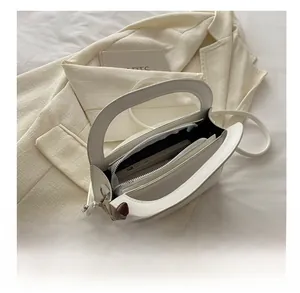 Interior view of white leather shoulder bag showing organized multi-layer compartments