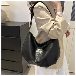 Détail du sac hobo en cuir noir avec un patch logo carré Fashion & Bag EST.1993