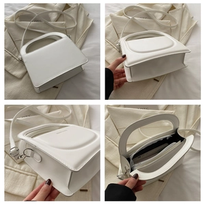 Macro view of white structured handbag showing sewing details and internal compartments