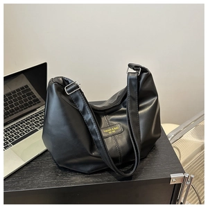 Gros plan détaillé d'un sac à bandoulière en similicuir noir avec boucle métallique