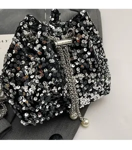 Dettaglio della borsa a secchiello con paillettes, catena in metallo e ciondoli di perle
