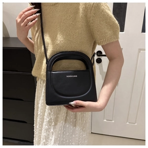 Detail of black matte leather handbag with Fashion & Bags text and cutout handle