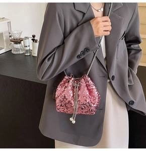 Dettaglio borsa a secchiello rosa con paillettes, catena argento e nappine di perle