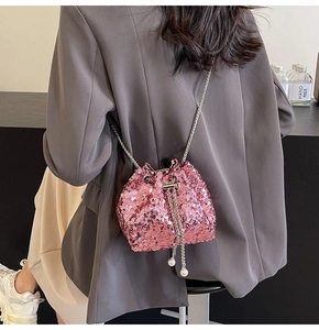 Détail du sac seau à paillettes roses avec cordon à perles et bandoulière chaîne