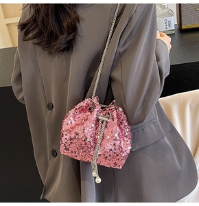 Détail du sac seau à paillettes roses avec bandoulière chaîne et cordon perlé élégant