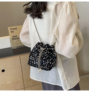 Détail du sac seau noir à paillettes avec bandoulière chaîne et breloques en perles