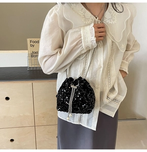 Détail du sac seau noir à paillettes avec chaîne argentée et cordon orné de perles