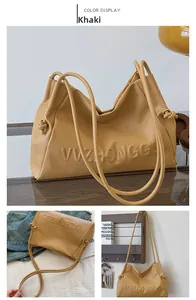 Detalle del bolso tote caqui en cuero suave con logo grabado y correa de hombro nuda
