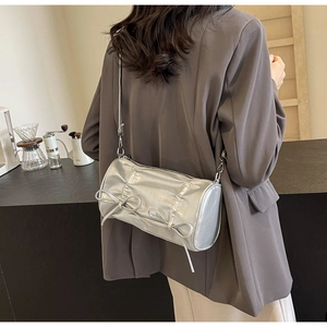 Silver pillow bag with metallic texture, detailed pleats, and three delicate ribbon bows