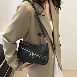 Stylish black denim shoulder bag with white stitching and decorative silver zipper