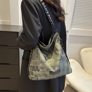 Large camouflage newspaper print tote bag with wide 'LOVE' lettered shoulder strap