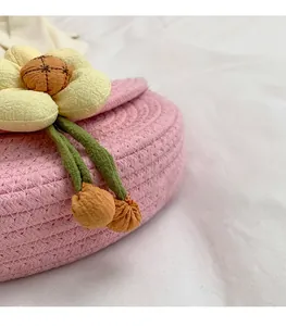 Macro shot of pink woven saddle bag showing fabric floral detail and texture