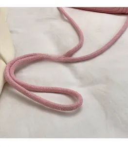 Detail of pink woven shoulder strap featuring smooth cotton cord texture and braided design