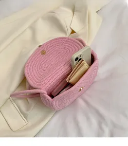 Detail of pink woven crossbody bag showing spacious interior with phone and wallet
