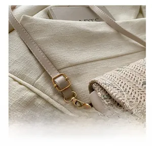 Detail of adjustable golden buckle and hardware on the beige woven shoulder strap