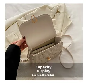 Detail of cream woven crossbody bag showing interior capacity with a smartphone