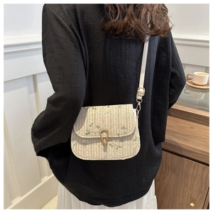 Detail of cream woven crossbody bag with floral embroidery and gold droplet clasp