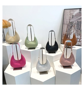 Minimalist hobo bags in seven colors displayed on geometric stands in a modern setup