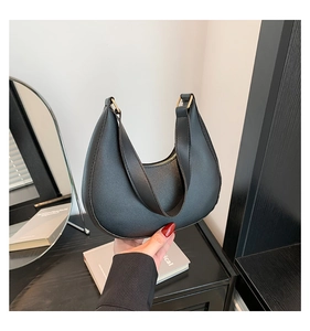 Detail shot of black crescent shoulder bag with matte leather and golden zipper closure