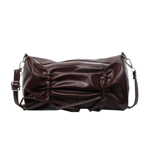Deep brown ruched cylinder shoulder bag with bow details and silver zipper on white backdrop