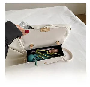 Internal view of the cream mini square bag showing space for phone, sunglasses and umbrella