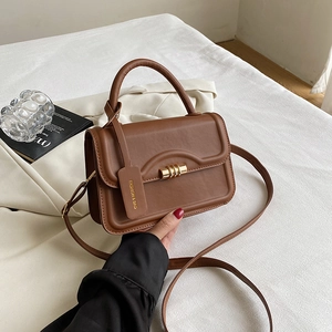 Detail der braunen Vintage-Handtasche aus PU-Leder mit goldenem Drehverschluss und Riemen
