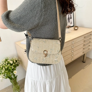 Chic woven shoulder bag with floral embroidery and adjustable strap shown on model