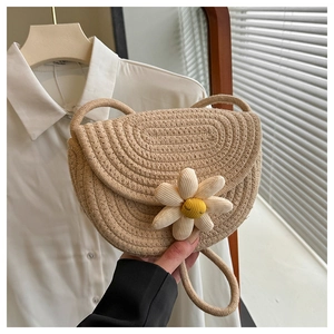 Dettaglio della mini borsa a tracolla intrecciata con margherita bianca e cordino