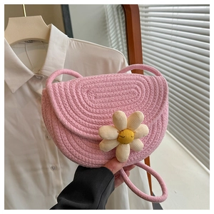 Vista dettagliata della borsa a tracolla intrecciata rosa con grande decoro a margherita