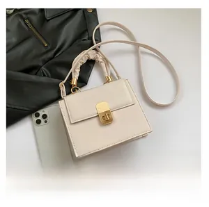 Detail of off-white mini square bag featuring gold twist lock and scrunchie handle