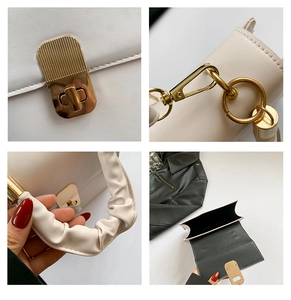 Detail view of the elegant lock buckle, ruched leather handle and golden metal hardware