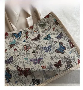 Detailopname van de duurzame canvas textuur en kleurrijke vlinderprint op de tas
