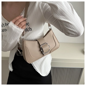 Detail of beige shoulder baguette bag featuring a large silver square metal buckle