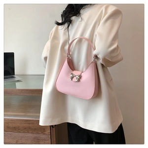 Borsa rosa a forma di mezzaluna con fibbia a fiocco argento indossata da una modella