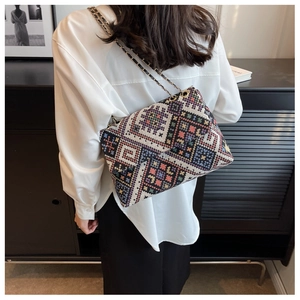 Ethnic geometric woven crossbody bag with colorful patterns and metal chain strap detail