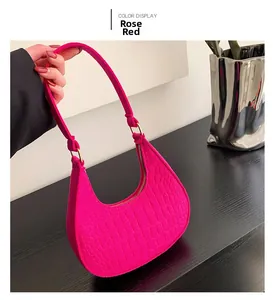 Detail of rose red half-moon bag with crocodile pattern and gold metal buckle