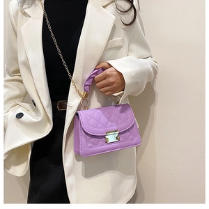 Detail view of a light purple quilted crossbody bag with a golden square lock and metal chain