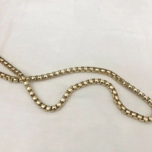Detailed view of a classic golden box chain necklace with high polish finish