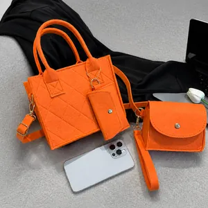 Detailed view of orange quilted felt tote bag set with matching mini pouch and chain strap