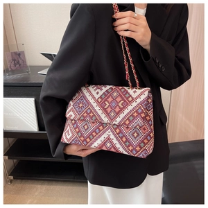 Detailed embroidery on a vintage ethnic style tote with geometric patterns and chain strap