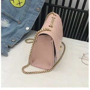Detailed side view of pink quilted handbag featuring gold metal chain and accordion style gusset