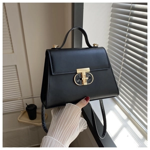 Detail view of the black matte PU leather handbag showing the gold twist lock and texture