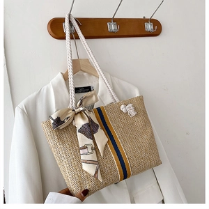 Straw woven tote bag with blue and yellow stripes, silk scarf, and tassel for beach holiday