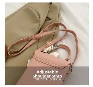 Detail of pink leather crossbody bag with silk scarf handle and adjustable strap