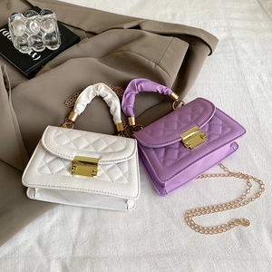 Detail of quilted leather crossbody bags with golden locks and chic scrunched handles