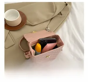 Interior view of pink chain crossbody bag showing capacity for phone and cosmetics