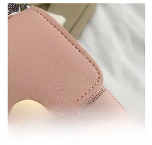 Close-up of pink lychee grain leather with checkerboard embossing and gold heart buckle