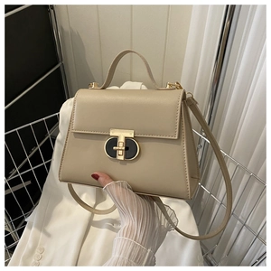 Dettaglio borsa in pelle sintetica beige con chiusura a girello nera e dorata