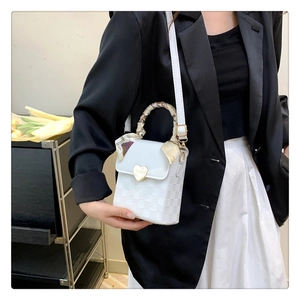 White textured square crossbody bag with gold heart clasp and floral scarf handle wrap
